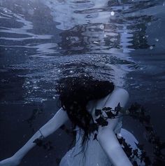 a woman floating in the water with her back to the camera