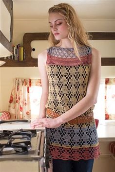 a woman standing in front of a stove top oven