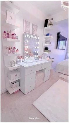 a white vanity with lighted lights and drawers in a small room next to a bed