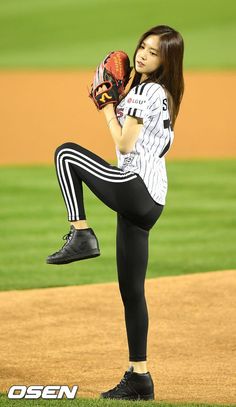 a woman in black and white baseball uniform holding a catchers mitt