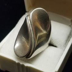 Vintage Sterling Silver Ring Modernist Designer Signed Unisex Size 5.5 US Large vintage abstract design Modernist sterling silver ring in very good vintage condition with age respective wear and patina, arrives gift boxed.  This is a stunning ring! Measures Approximately: 28 mm Wide (at center front area) 2.5 mm Wide (at center back) Weight:  8.5 Grams Hallmarks:  Sterling & Designer's $ Hallmark We do Combined Shipping Ask For a new invoice when finished shopping Mint - shows little to no indication of handling. Excellent - shows very minor evidence of handling. Very Good - shows evidence of wear and handling, with no major flaws. Good - shows moderate wear and is fully functional. Fair - shows moderate wear and has condition issues that may or may not be repairable. PLEASE READ All Props Vintage Silver Concave Ring, Link Art, Vintage Sterling Silver Rings, Cufflink Set, Vintage Rhinestone, Ring Box, Set Vintage, Rings Statement, Sterling Silber