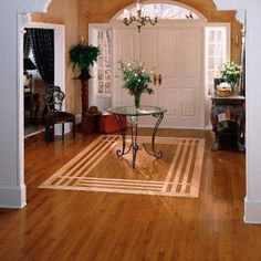 a living room with hard wood flooring and white trim on the door way to another room