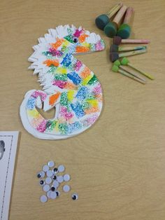 the paper plate is next to crayons and other crafting supplies on the table