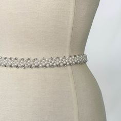 This beautiful bridal belt combines a combination of elegant pearls and dainty crystals to bring a bit of sparkle to your bridal look. The perfect accessory to finish off your wedding dress or bridal separates, this belt is designed to sit on the waistline and has a concealed fastening at the back.  When ordering please let us know your waist measurement in inches so we can make this perfectly to size.  We use high quality bridal fabrics for our pieces - we portray the colour and textures of our Wedding Bridal Belt Beaded With Pearls, Wedding Bridal Belt With Beaded Pearls, Wedding Pearl Beaded Bridal Belt, Elegant Beaded Bridal Belt, Elegant White Belt With Rhinestones, White Rhinestones Bridesmaid Bridal Accessories, Elegant Beaded Fitted Bridal Belt, Elegant Pearl Embellished Bridal Belt For Wedding, Elegant Pearl Embellished Bridal Belt