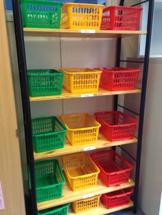 the shelves are filled with different colored plastic baskets