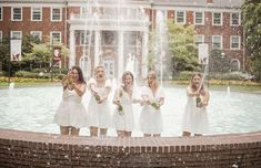 a group of women standing next to each other in front of a fountain