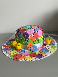 a cake decorated with flowers and birds on a table next to a cupcake holder