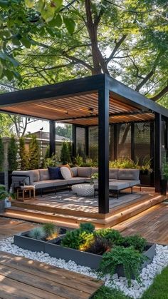 an outdoor living area with wooden decking and plants on the ground, surrounded by trees