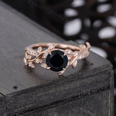 a black and white diamond ring sitting on top of a wooden table