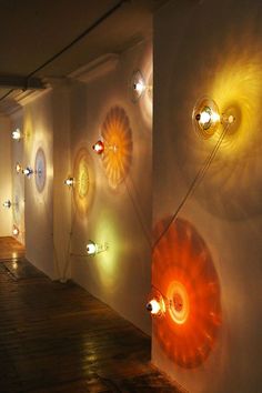 a room with several lights on the wall and various circular objects hanging from the walls