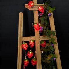 a wooden ladder decorated with lights and strawberries