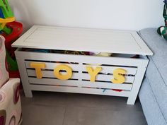 a toy chest sitting next to a blue couch