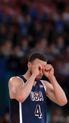 a basketball player holding his hands to his face