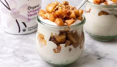 two jars filled with food sitting on top of a marble counter next to an ice cream container