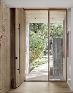 an open door leading into a room with wooden walls and doors that lead to the outside