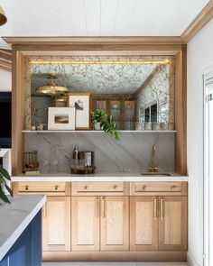 a kitchen with marble counter tops and wooden cabinets, along with gold trimmings