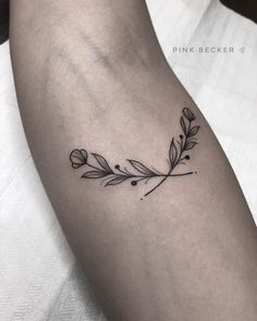 a black and white photo of a woman's arm with a flower tattoo on it