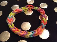 a multicolored bracelet on a black background with silver polka dotes and circles