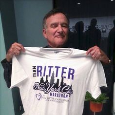 a man holding up a white t - shirt with the words rittener new york marathon on it