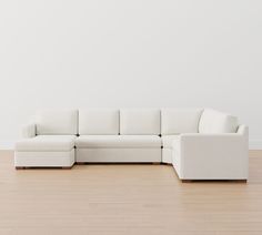 a white couch sitting on top of a hard wood floor next to a white wall