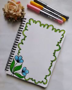 an open notebook with flowers and markers next to it