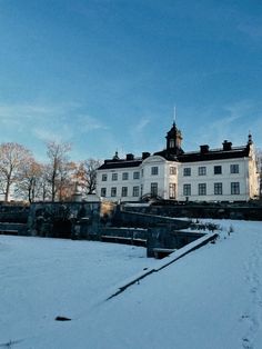 a large white building sitting on top of a snow covered field