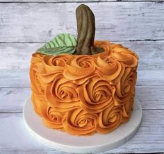 a cake decorated with orange icing and flowers on top of a white platter