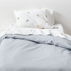 an unmade bed with blue and white sheets