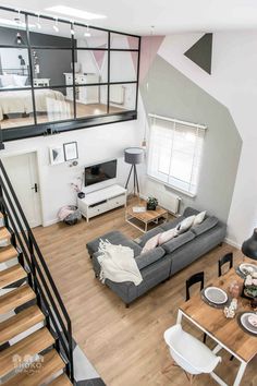 a living room filled with furniture next to a stair case in a loft style home