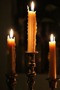 three lit candles sitting on top of a table