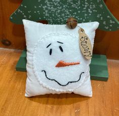 a white pillow with a snowman face on it