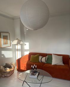 a living room filled with furniture and a large white ball hanging over the top of it