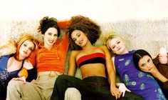 four women are laying on a couch together