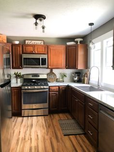 a kitchen with wooden floors and stainless steel appliances