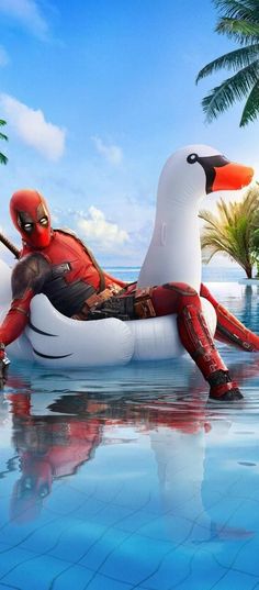 deadpool is sitting on an inflatable duck