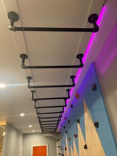 an indoor climbing wall with purple lighting