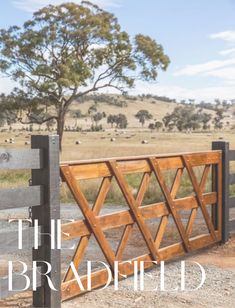 a wooden gate with the words, the bradfield on it in front of an open field