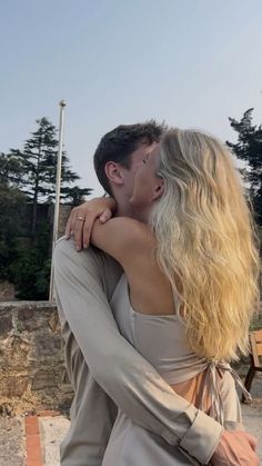 a man and woman kissing in front of a bench