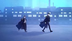 two anime characters are walking in front of some buildings