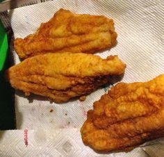 three fried food items sitting on top of a piece of paper next to a green box