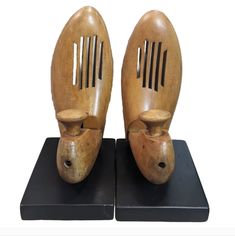 pair of wooden shoes on black stand with white background