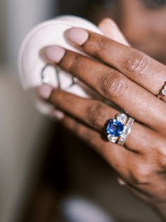 a close up of a person wearing two rings and holding a cup with something in it