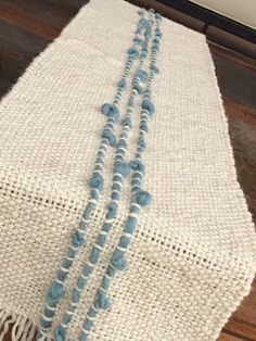 three strands of blue glass beads on a white table runner