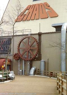 an industrial building with a large metal wheel on the front