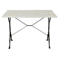 a white marble table with black iron legs