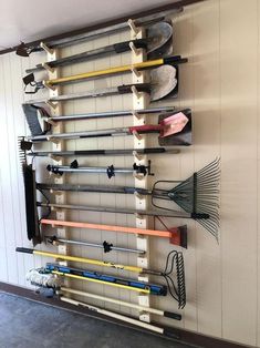 a wall mounted rack with many different types of tools hanging on it's sides