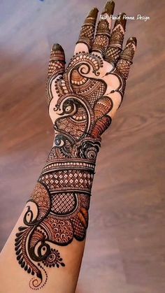 a woman's hand with henna tattoos on it