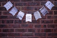 a paper banner is hanging on a brick wall with clothes pins attached to the string