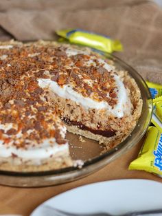 a pie sitting on top of a wooden table next to a bag of s'mores