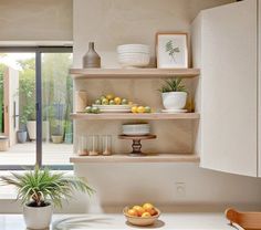 the kitchen is clean and ready to be used for cooking or eating, with fruit on the shelves